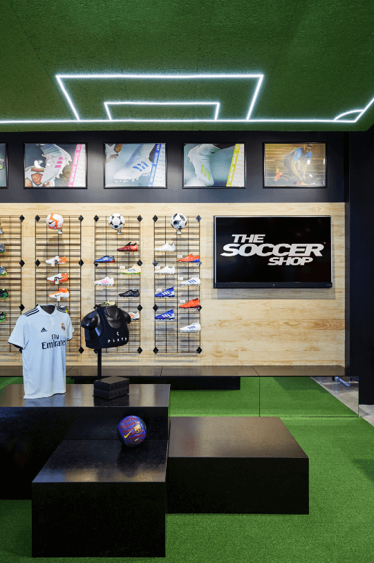 Bespoke signage, concrete flooring and black and timber walls for this retail fit out for The Soccer Shop