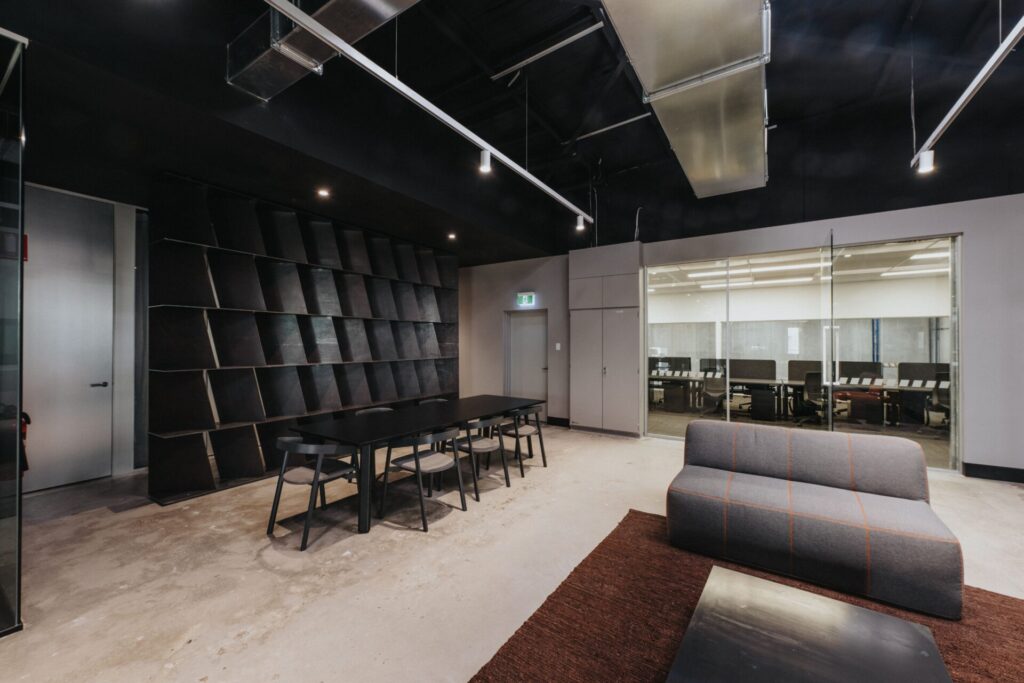 Mesh barrier ceilings, bold black and orange colour palette and striking reception area for this office fit out for Raubex, Total Fitouts Perth South